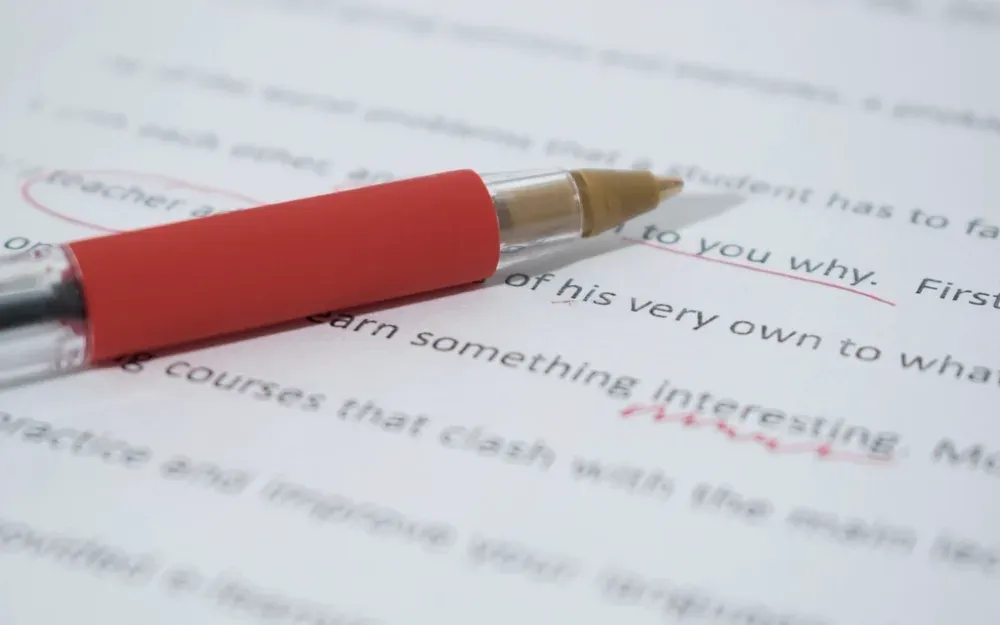 Stylo rouge posé sur un texte relu et corrigé